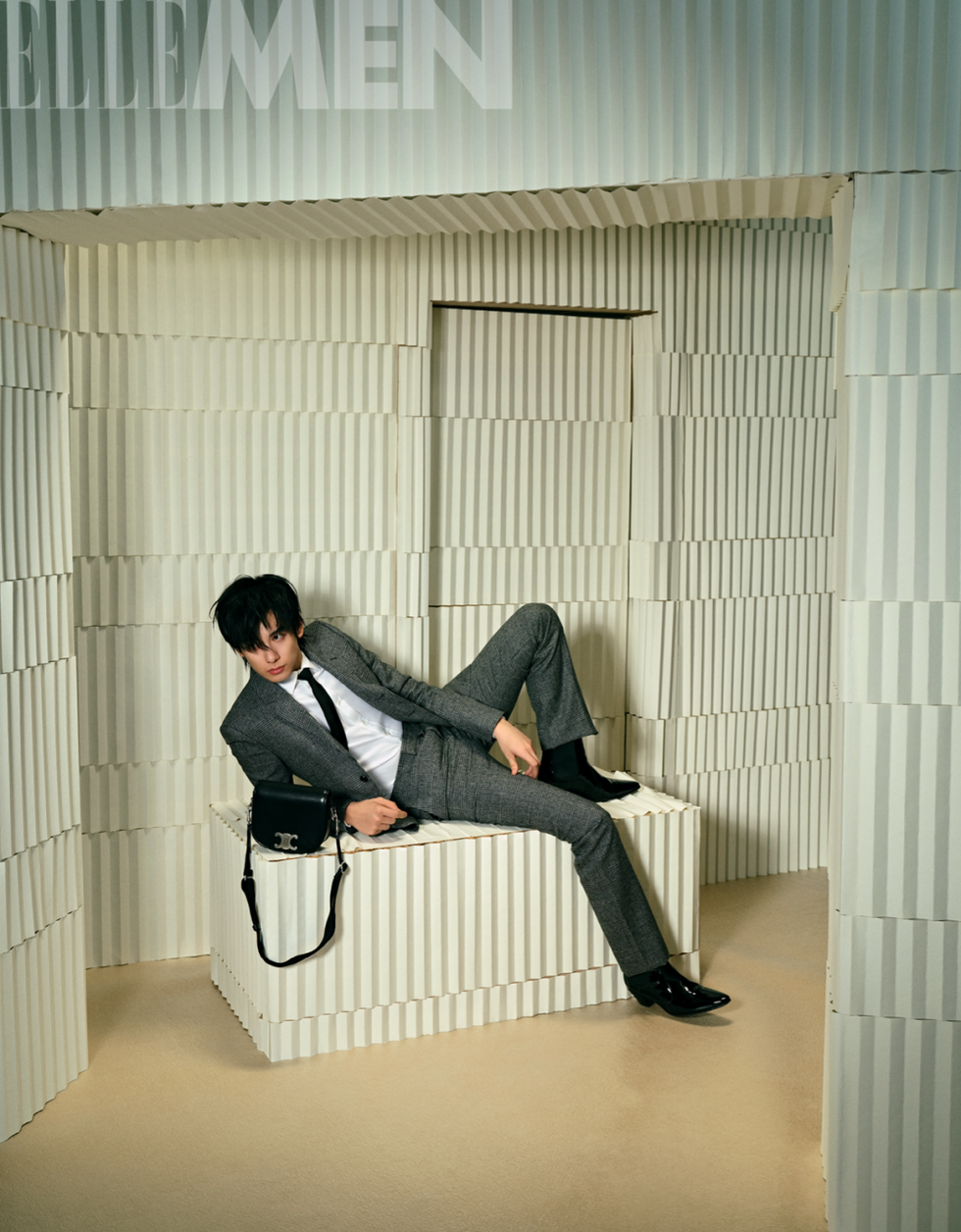 a person in a suit lounging in a minimalist textured environment
