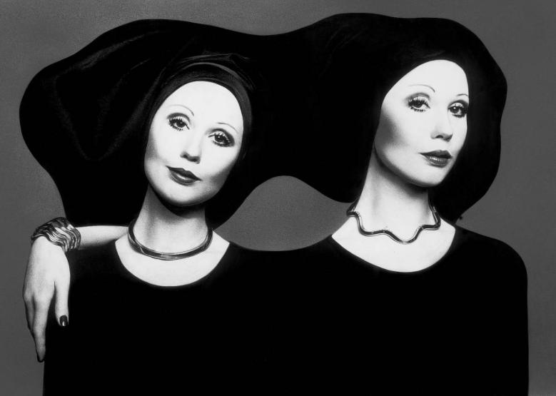 two individuals wearing black clothing and distinctive head coverings