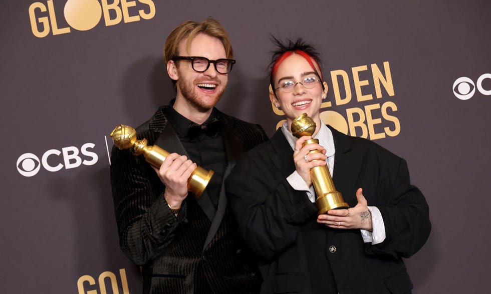 two men holding trophies