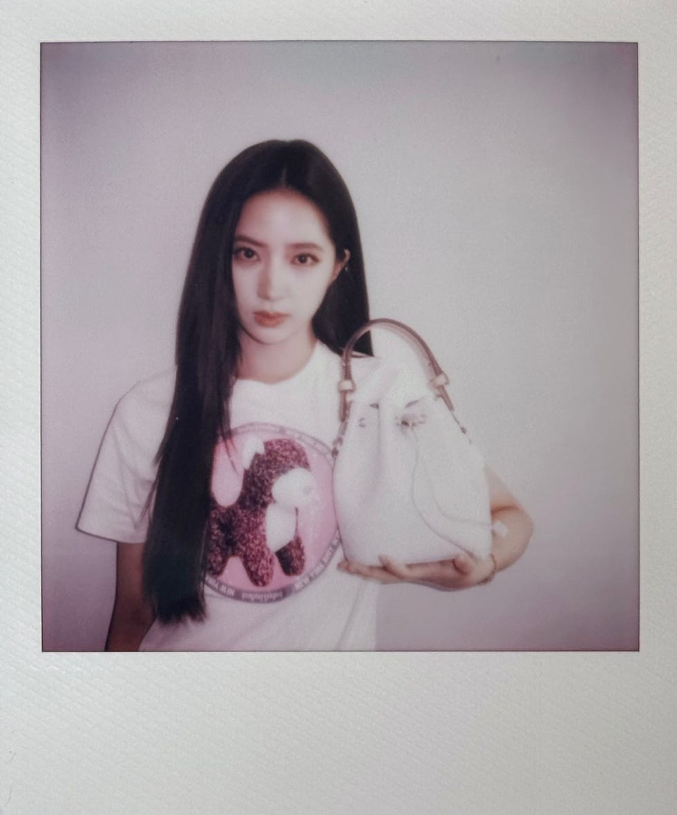 the image showcases a person holding a stylish handbag wearing a graphic tshirt