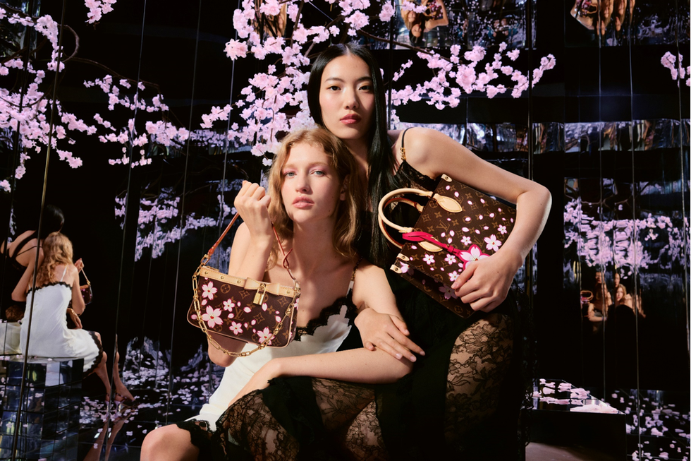 two women showcasing floralpatterned handbags in a mirrored environment