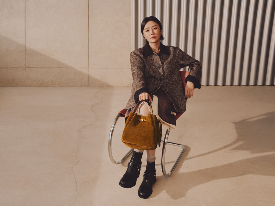 a seated figure holding a handbag in a modern setting