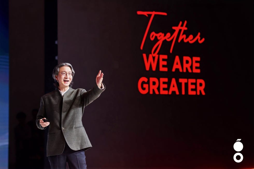 a speaker presenting on stage with a backdrop displaying an inspirational message