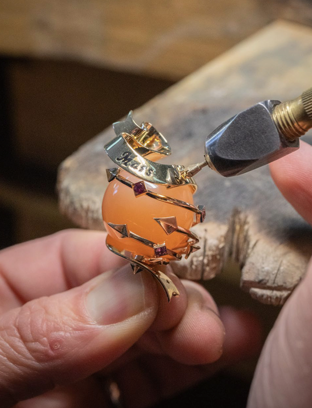crafting a unique ring featuring a peachcolored stone and gold accents