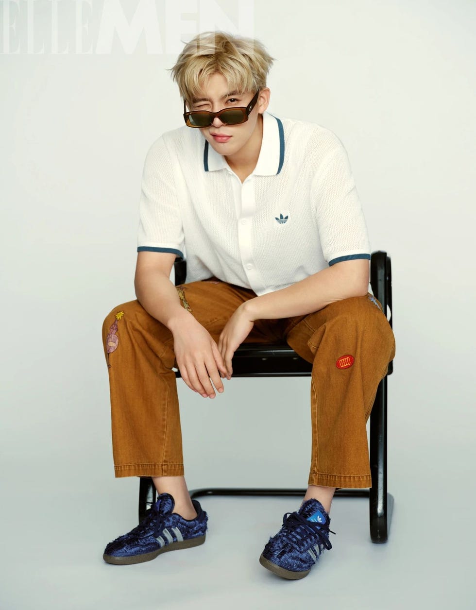 a person seated in a black chair wearing casual clothing