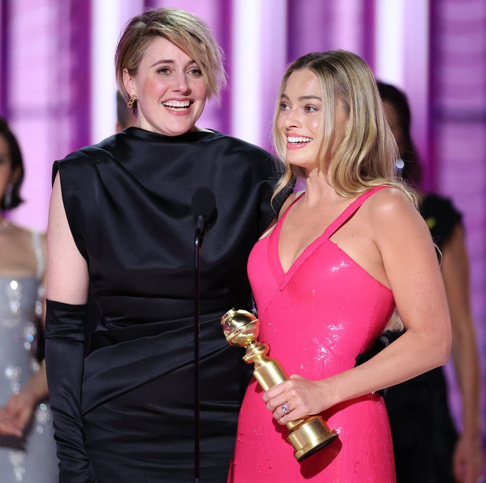 a couple of women holding a trophy