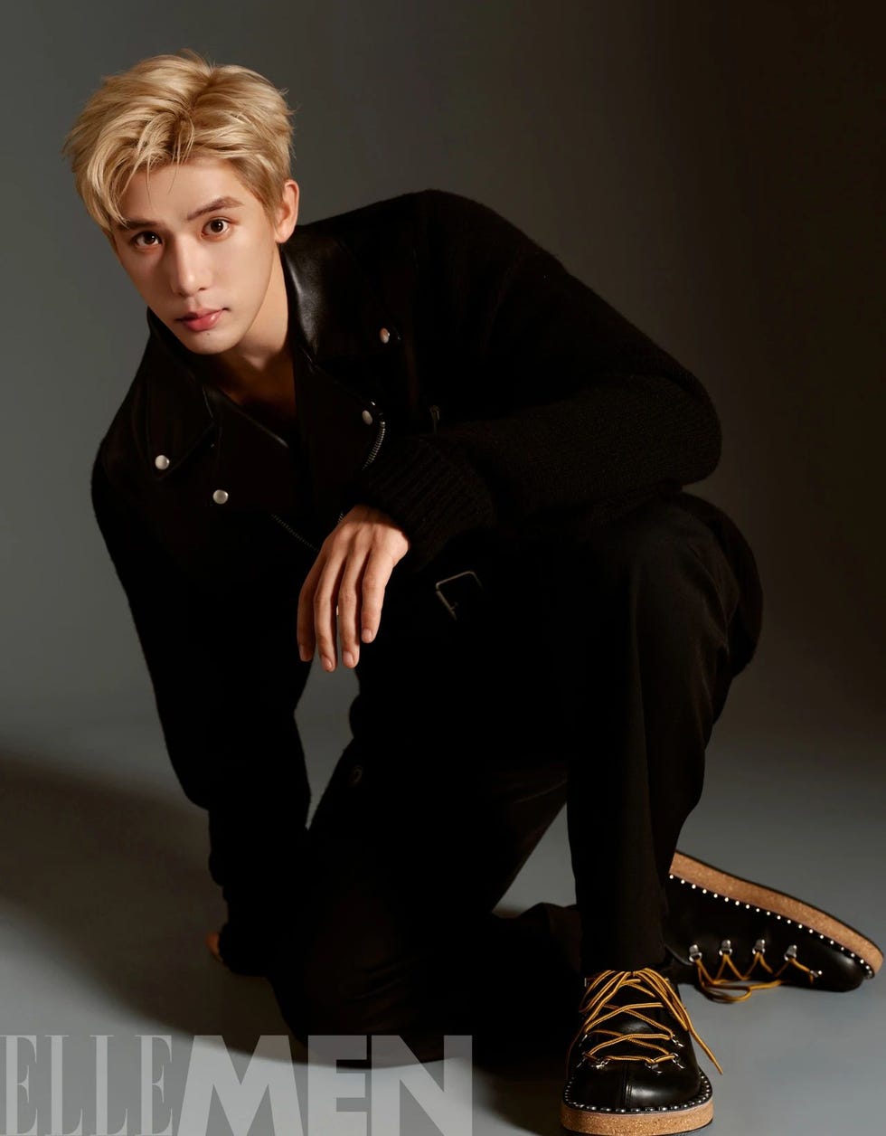 a model in a stylish outfit kneeling in a studio setting