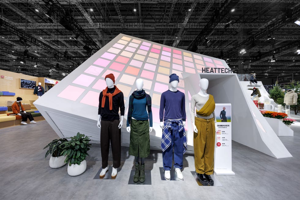 fashion display featuring mannequins in various outfits with an angled backdrop highlighting heattech