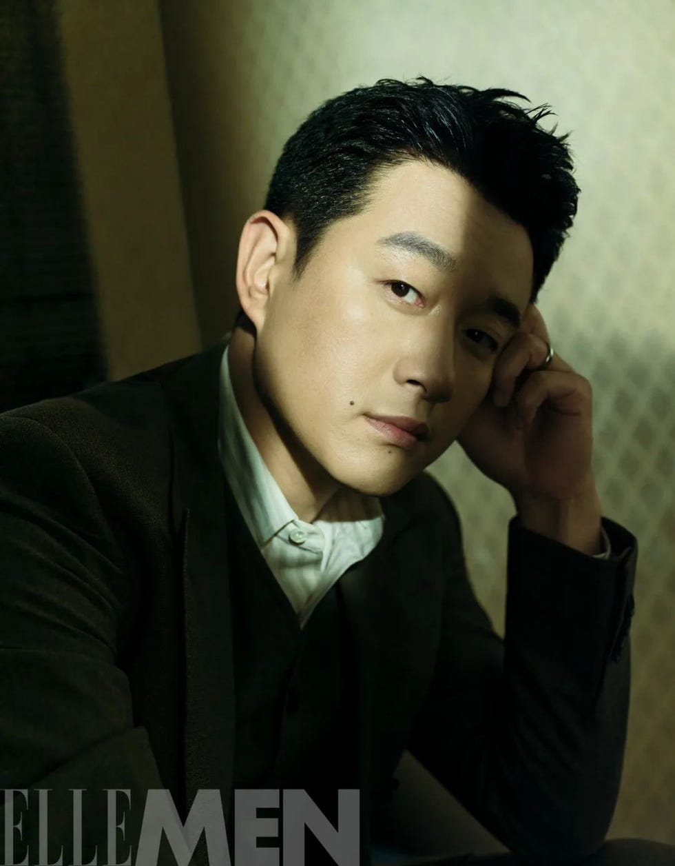 portrait of a man leaning on his hand featuring stylish attire
