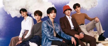 group of individuals posing in a creative setting with clouds in the background
