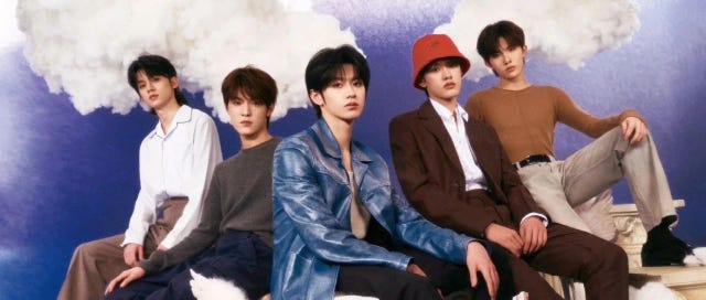 group of individuals posing in a creative setting with clouds in the background