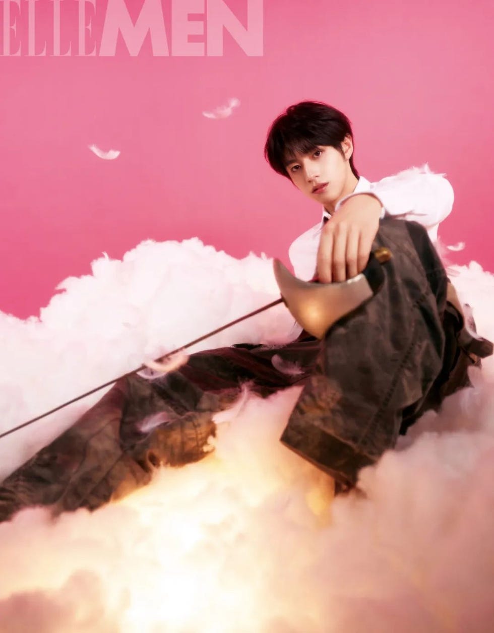 fashion editorial featuring a model seated on a cloudlike background with a sword