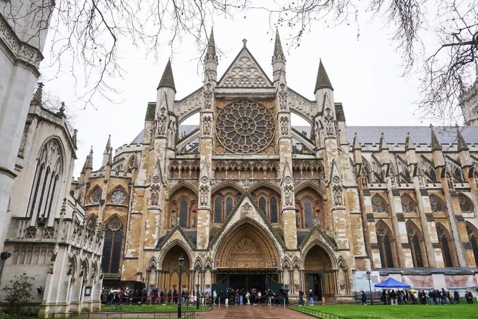 facade of westminster abbey with a queue of visitors