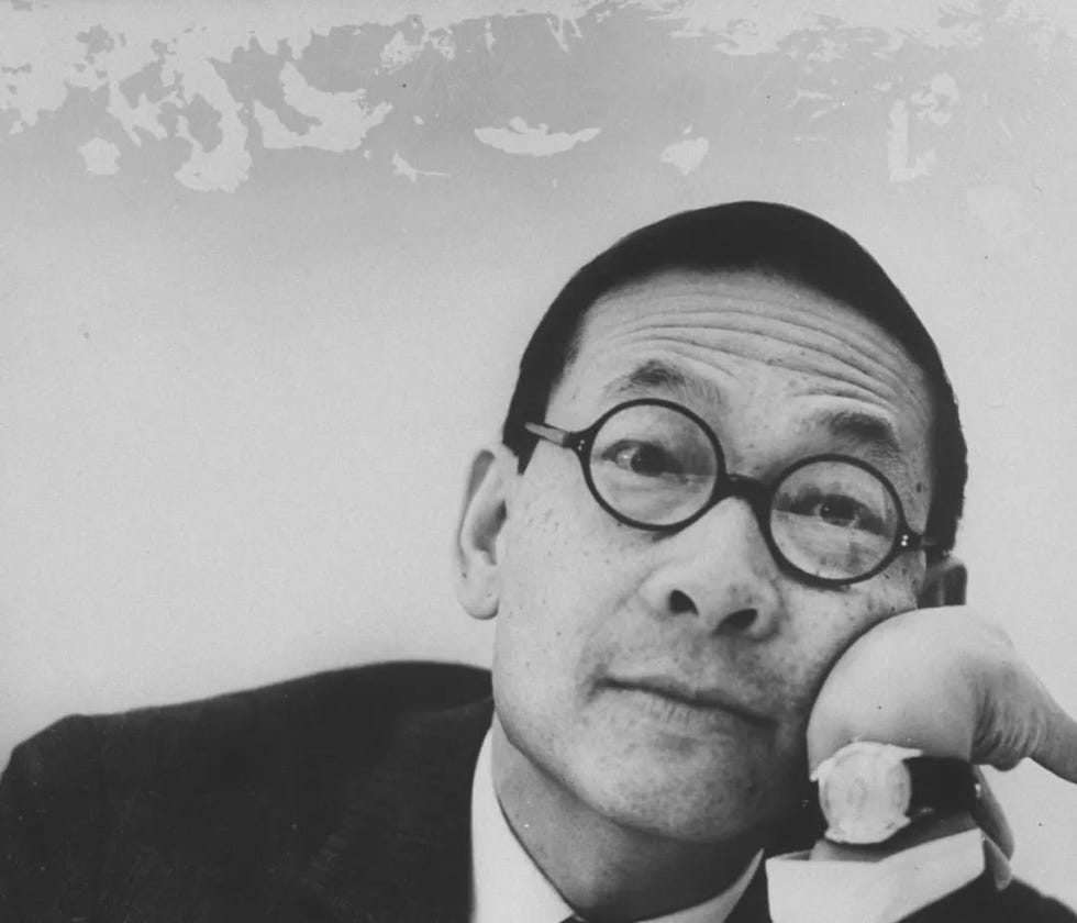 portrait of a man in formal attire resting his chin on his hand