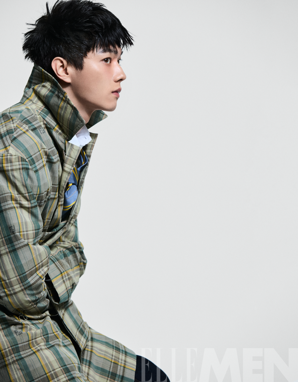 a person wearing a plaid coat with a folded collar and layered clothing