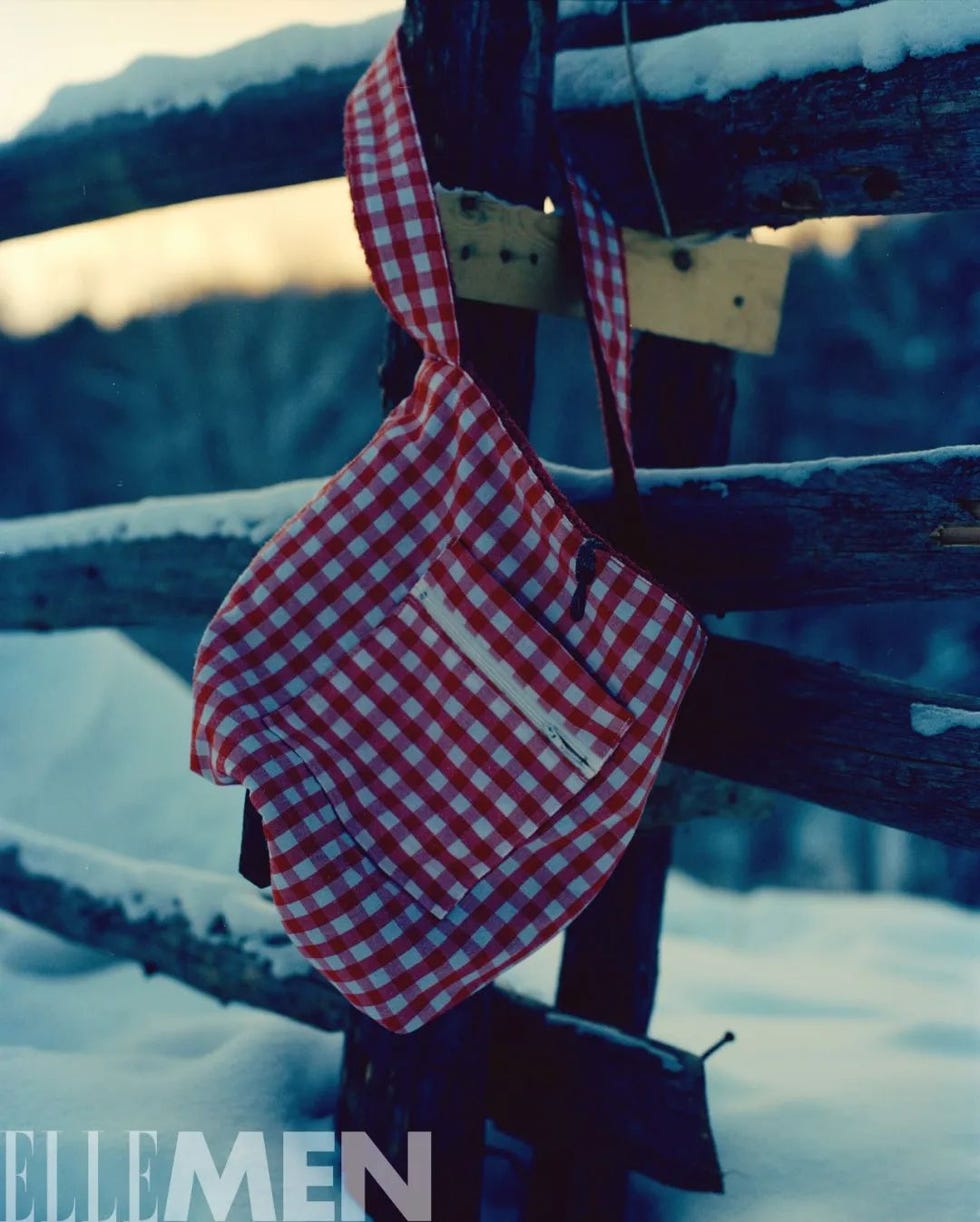 a red and white checkered bag hanging on a wooden fence