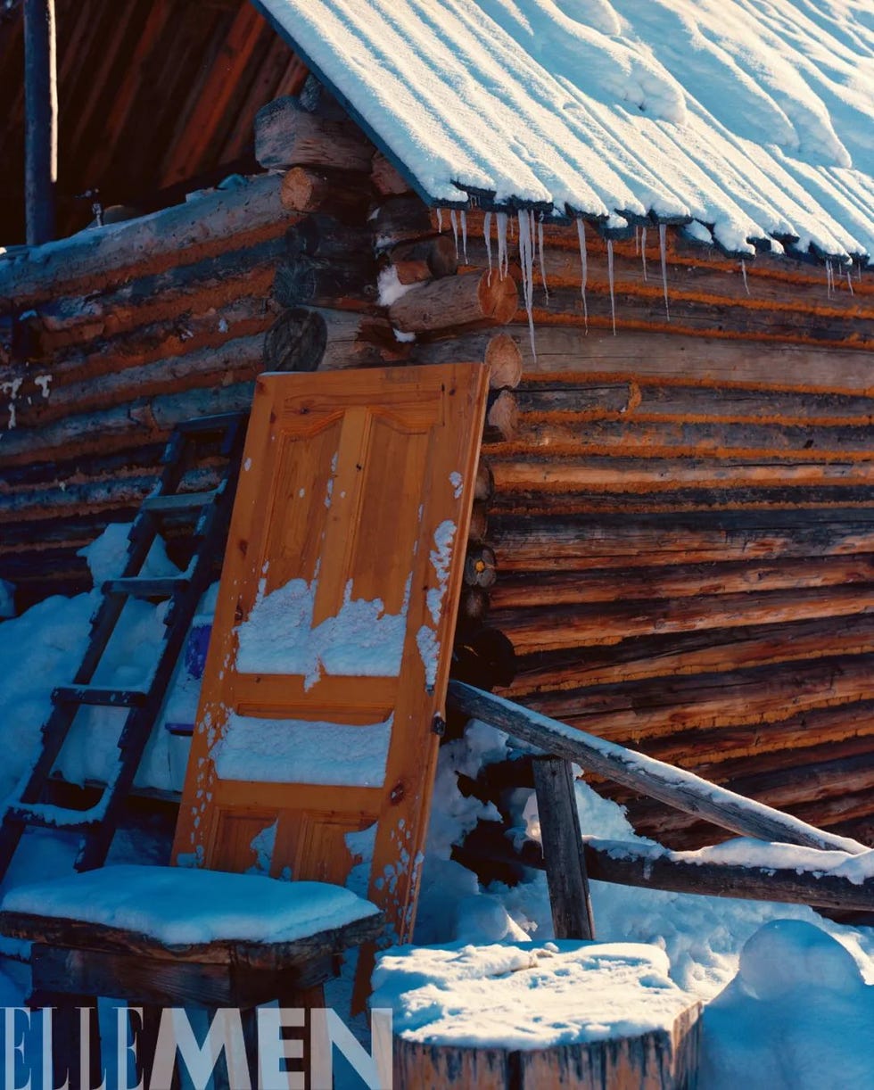 snowcovered wooden cabin with an abandoned door and a ladder