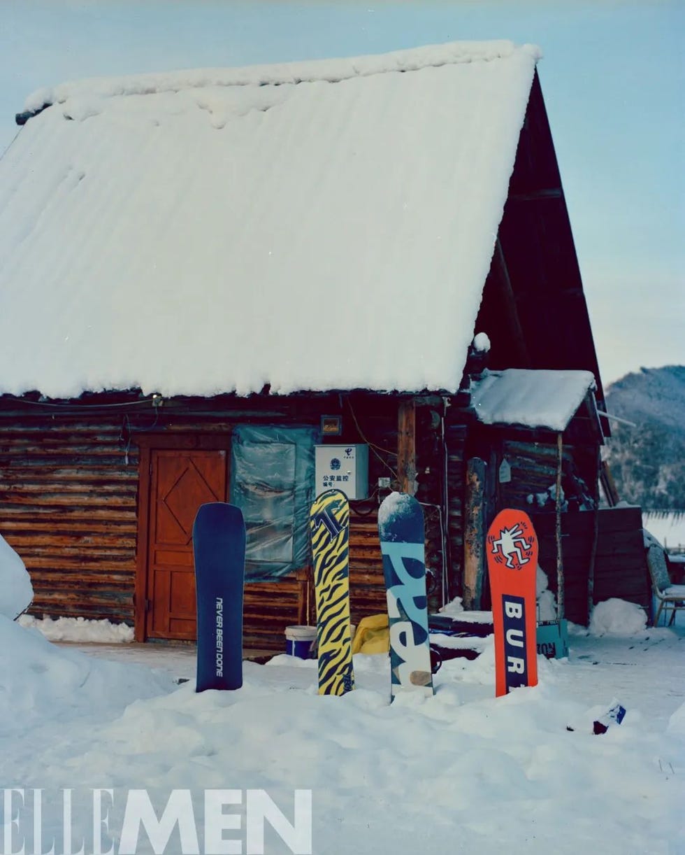 snowy cabin with snowboard gear in front