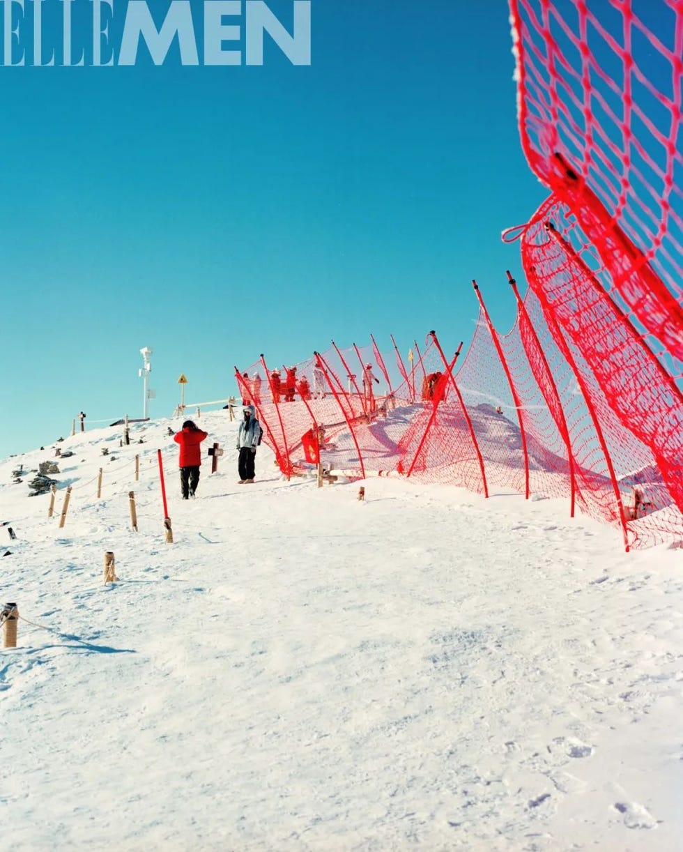 snowcovered hill with people and a red safety net