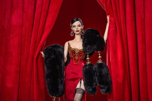 a person in a red dress and black fur coat with a black dog