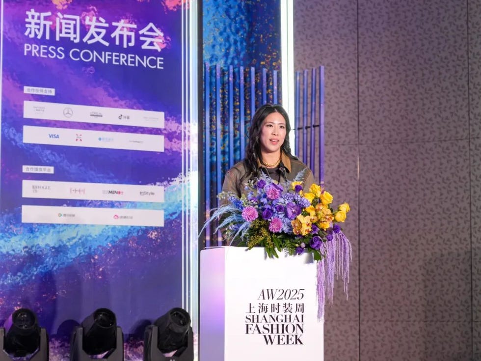 press conference setup featuring a podium with flowers and a backdrop of sponsors