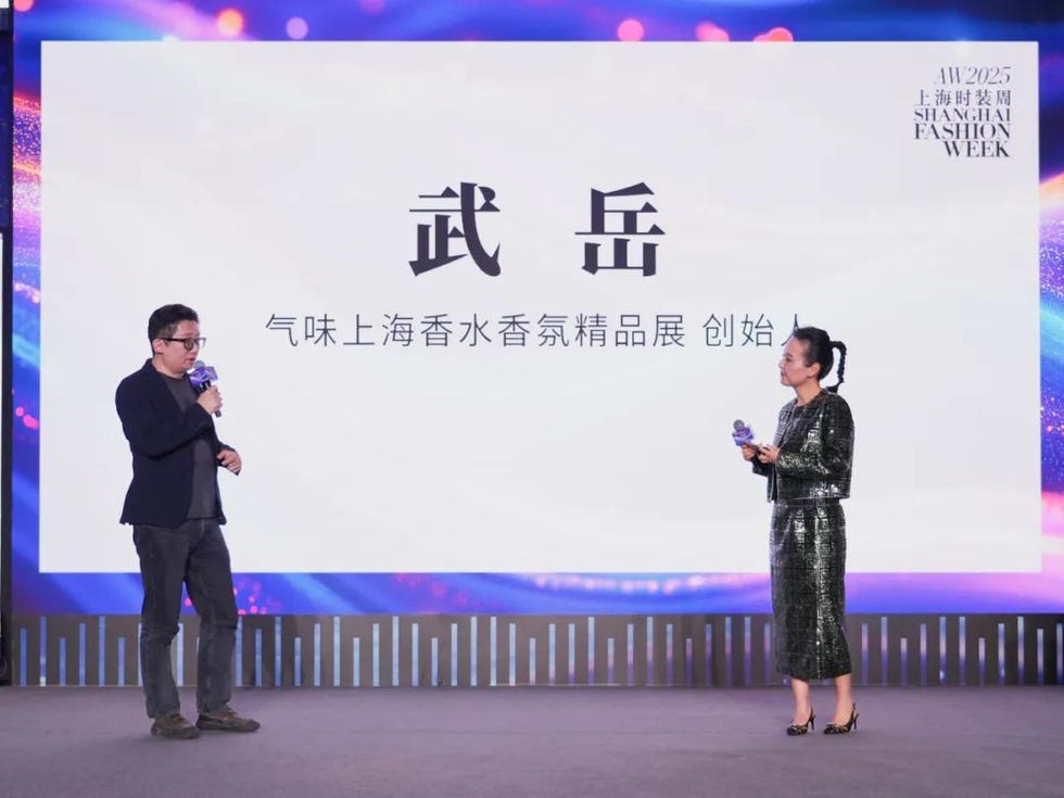 presentation at shanghai fashion week featuring two speakers and a large screen with text