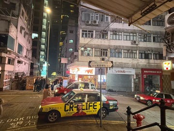 urban street scene at night with taxis and buildings