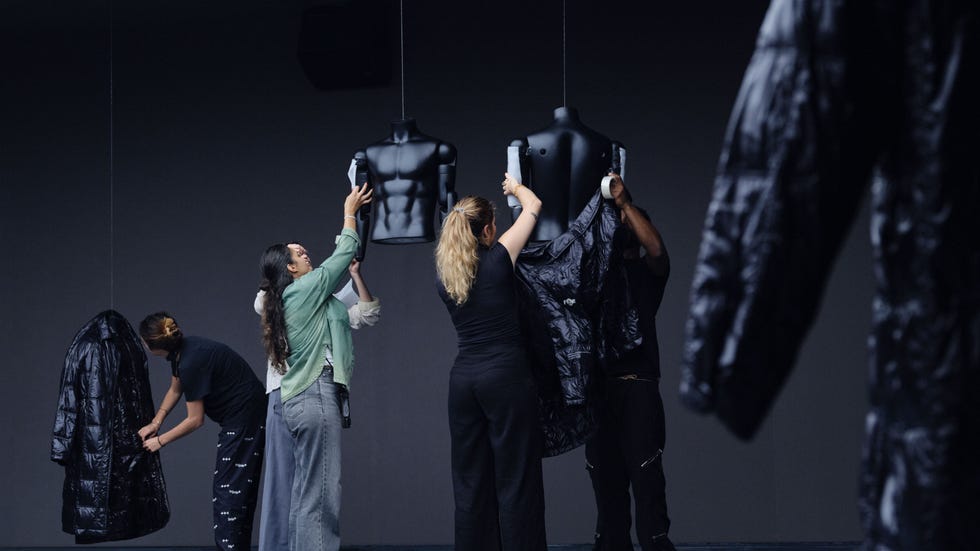 fashion professionals preparing clothing on mannequins in a studio setting