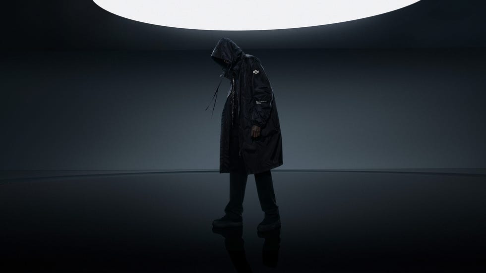 streetwear fashion piece featuring a long black hooded jacket