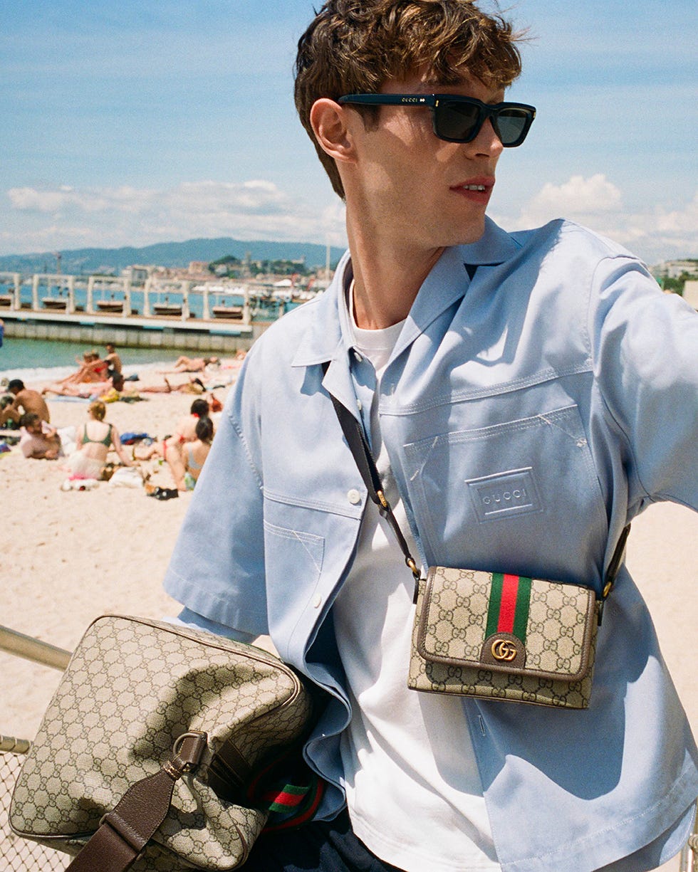 a person wearing designer clothing and accessories at a beach