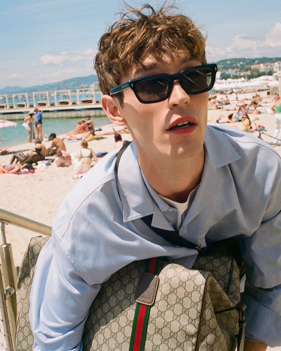 individual with a designer bag at a beach setting