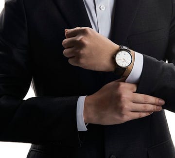 Suit, Formal wear, Tuxedo, Hand, Wrist, Gesture, Outerwear, Finger, Businessperson, White-collar worker, 