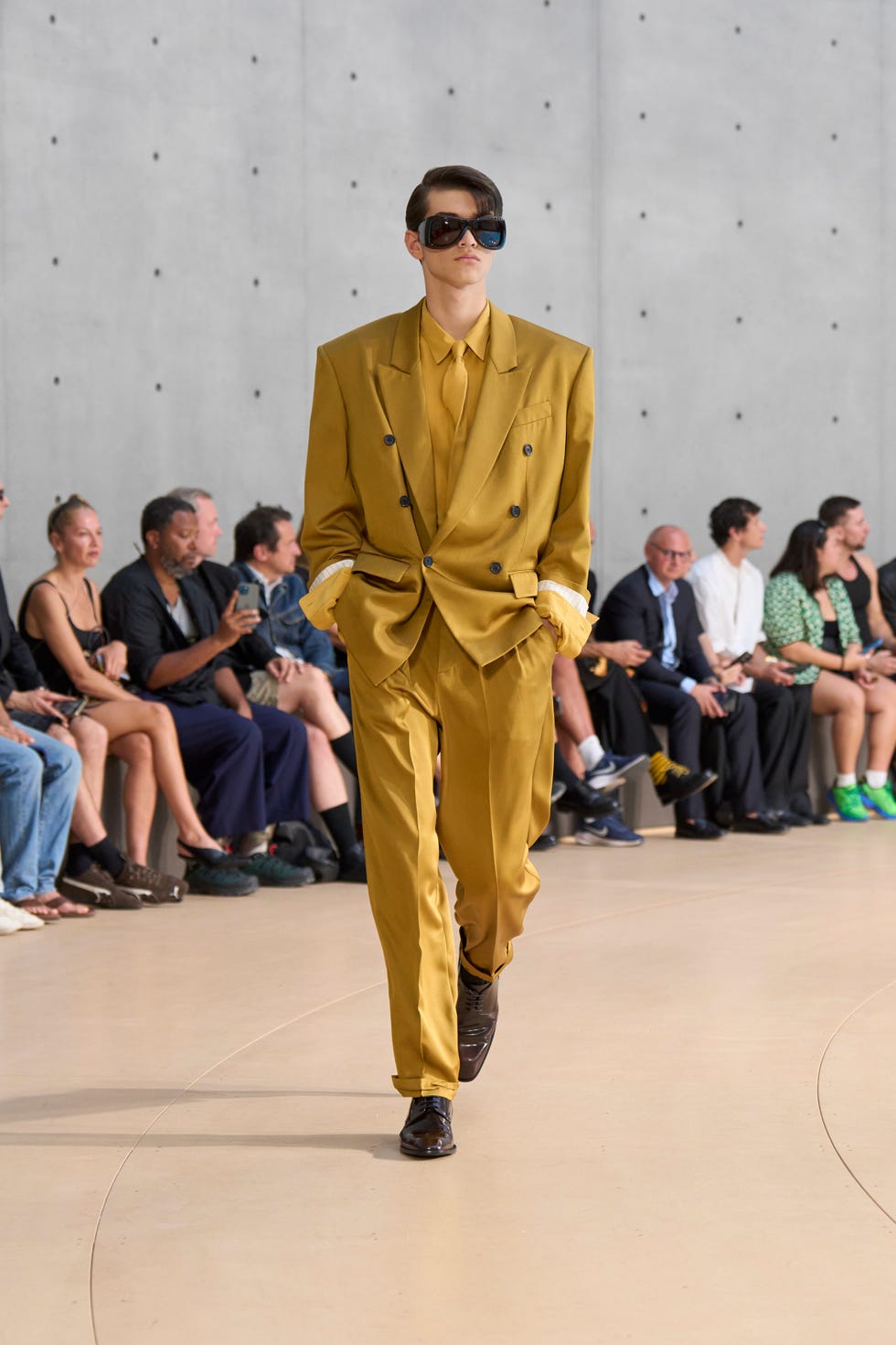 Fashion model showcasing a mustard suit on a runway