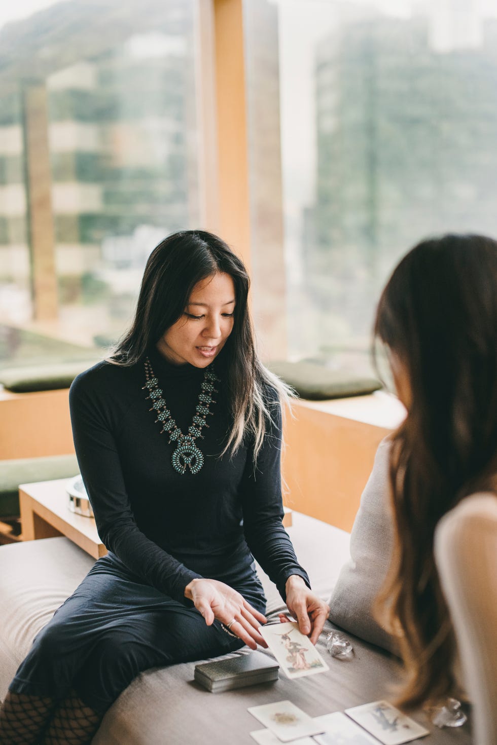 two individuals engaged in a card reading session indoors