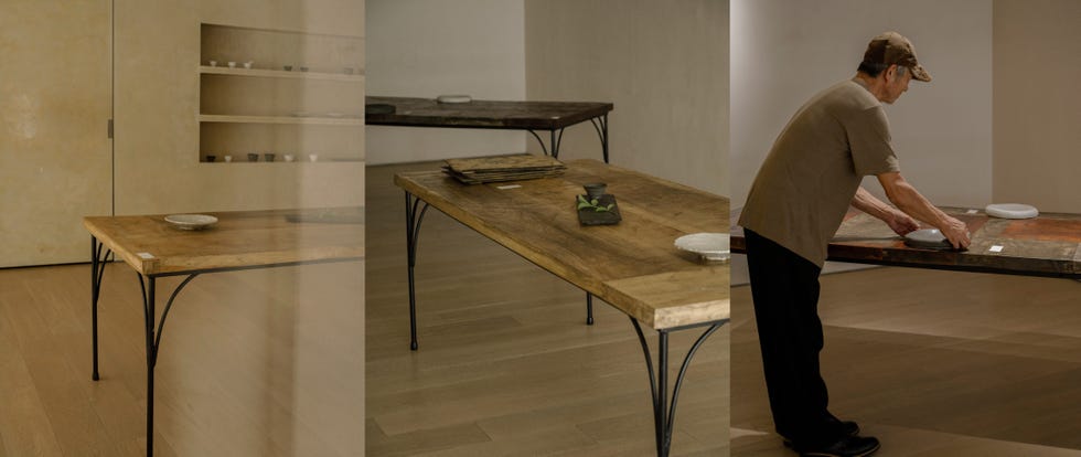 a person arranging items on wooden tables in a minimalist space