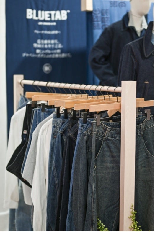 display of denim jeans and shirts in a clothing store