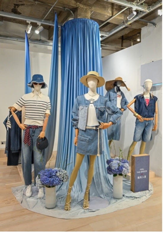 display of summer fashion apparel on mannequins surrounded by decorative elements