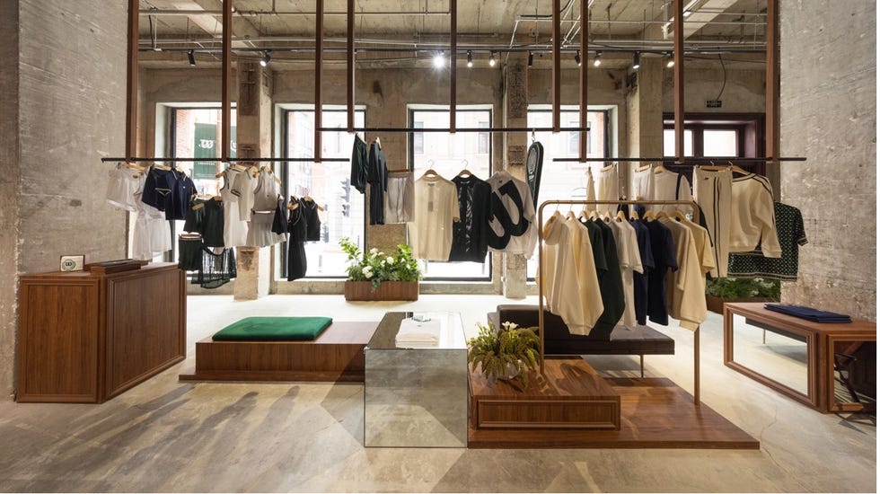 retail space displaying clothing on racks with seating areas