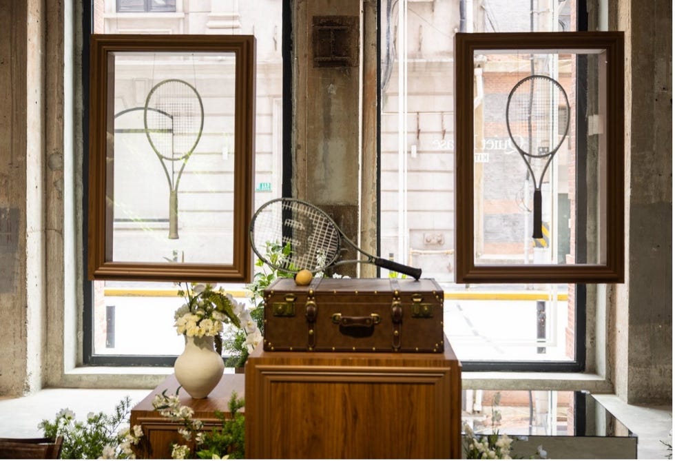tennis racks framed on windows with a vintage suitcase and flower arrangements