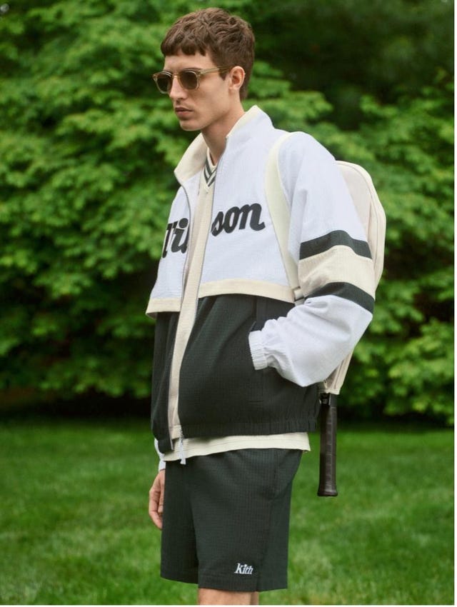 a person stands in a park wearing a sporty outfit