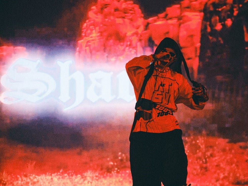 a performer engaging with the audience against a dramatic red backdrop