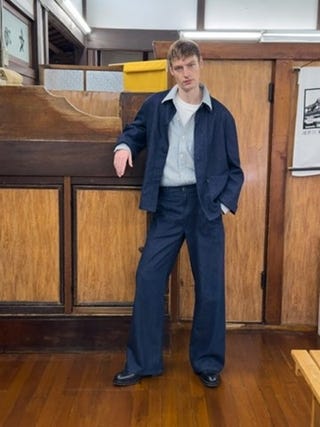 person wearing a casual outfit in a wooden interior