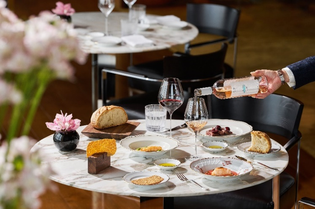 elegant dining setup with various dishes wine and bread on a marble table