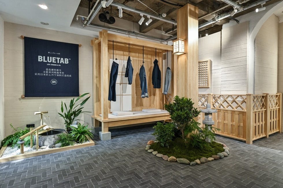interior display featuring bluetab by levi strauss co with hanging denim garments and a serene garden area