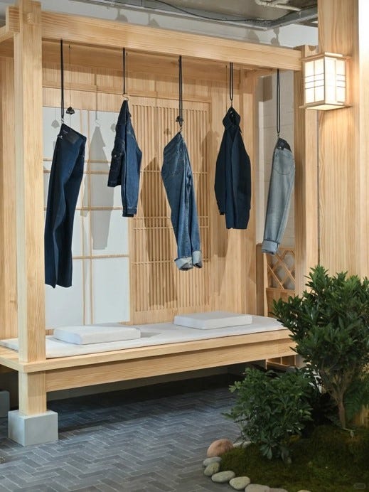 display of hanging denim garments in a wooden structure