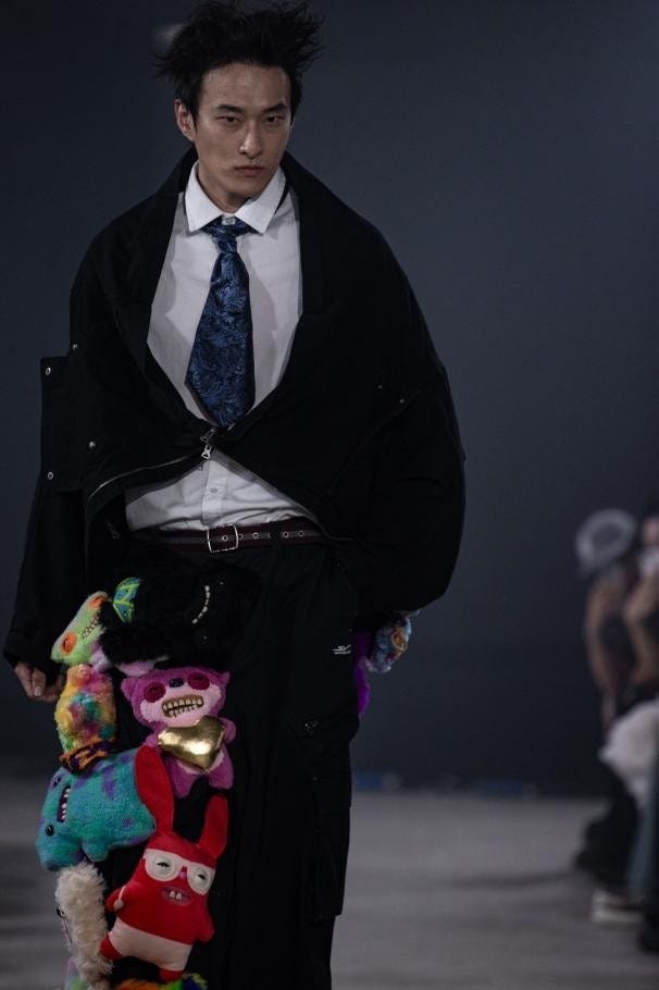 fashion model showcasing a unique outfit with plush toys