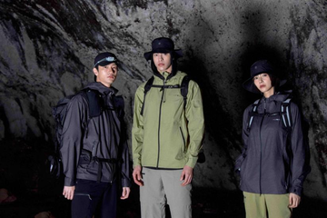 three individuals in outdoor gear standing in a cave
