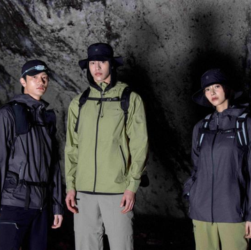 three individuals in outdoor gear standing in a cave three individuals in outdoor gear standing in a cave