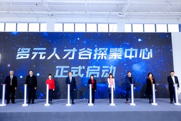 a group of people standing in front of a large blue sign