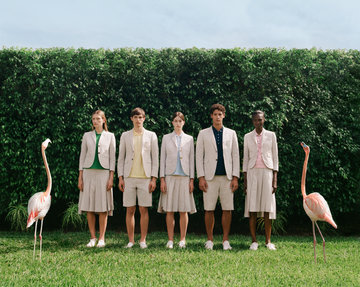 group of individuals wearing coordinated outfits standing next to flamingos